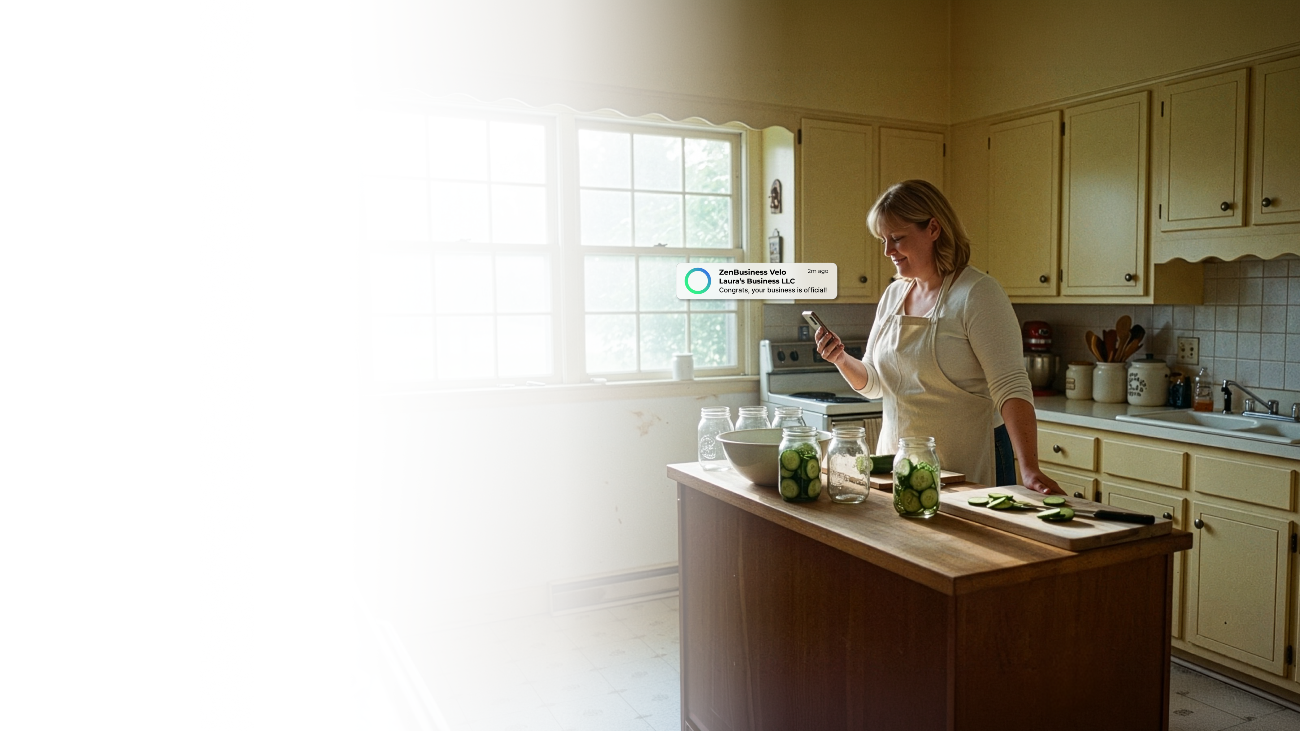 Female home food business owner in a Mississippi kitchen with mason jars of pickled vegetables on the counter reading her ZenBusiness Velo notification that her LLC is approved