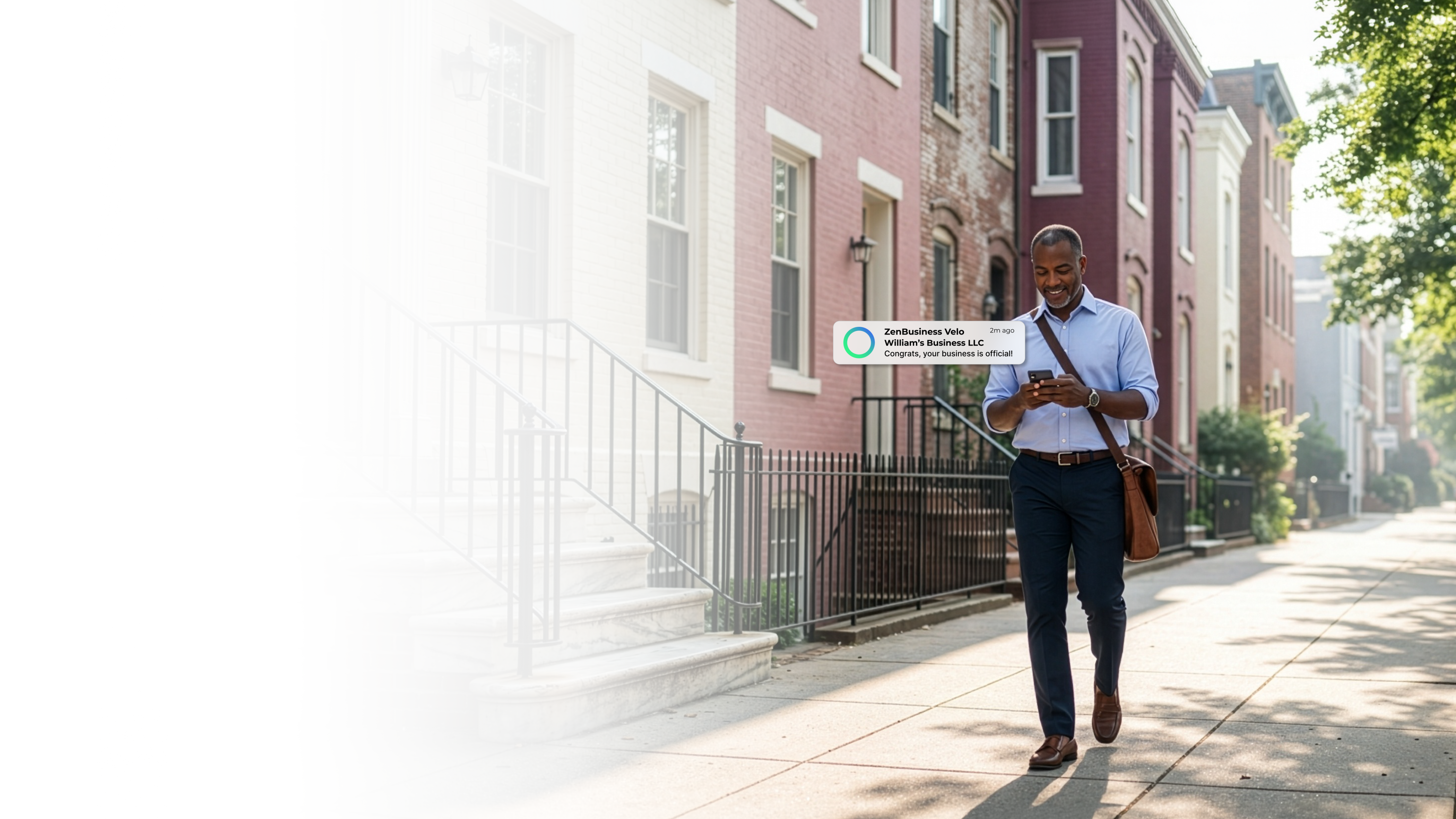 Male business professional walking down a sunny Washington DC sidewalk past brick row houses after receiving his ZenBusiness Velo notification that his LLC is approved