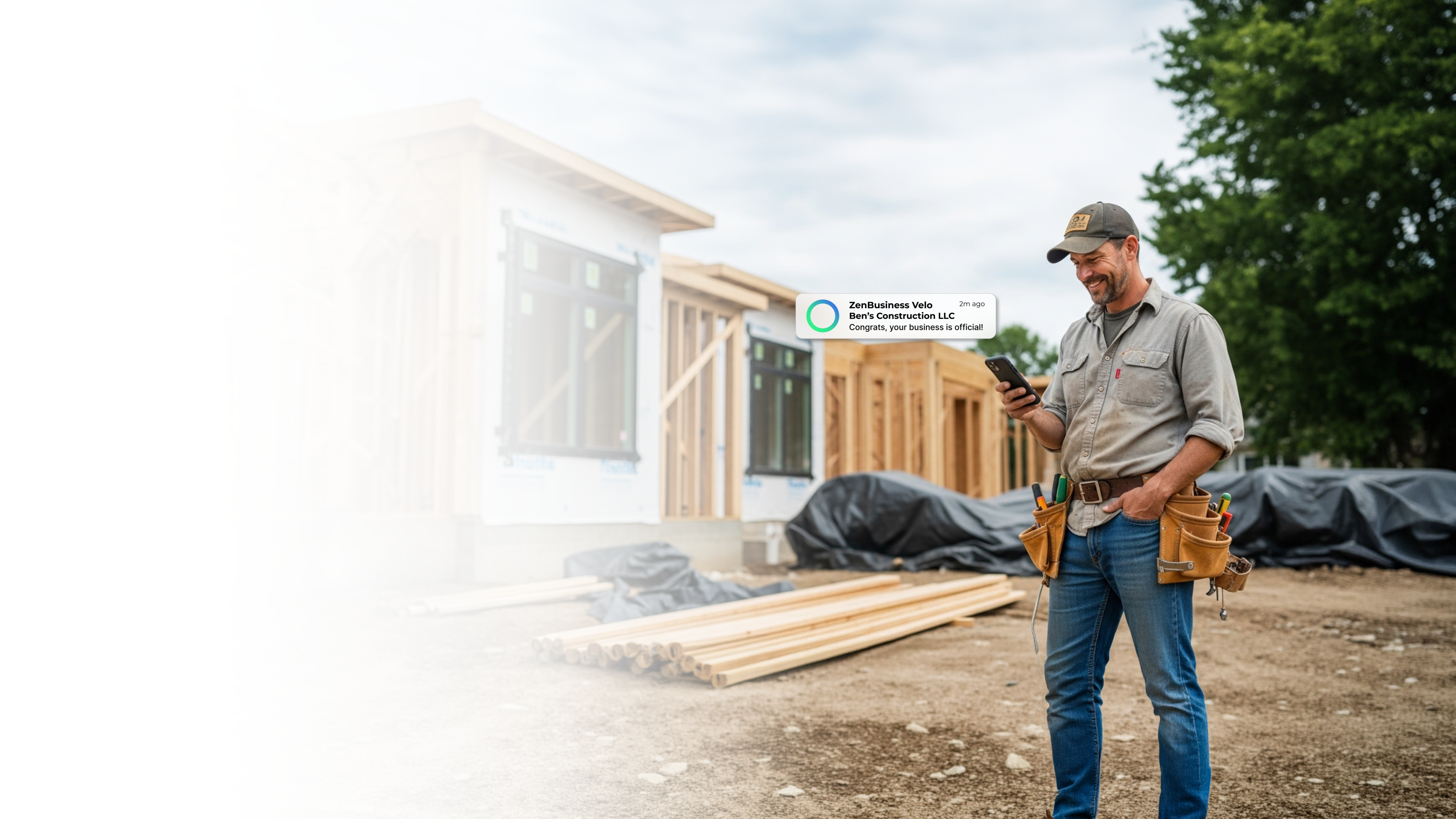 Male construction contractor on an Indianapolis Indiana job site with a newly framed house behind him after ZenBusiness Velo confirmed his LLC