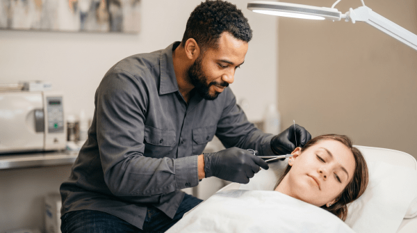 Body piercing studio owner performing a professional body piercing service