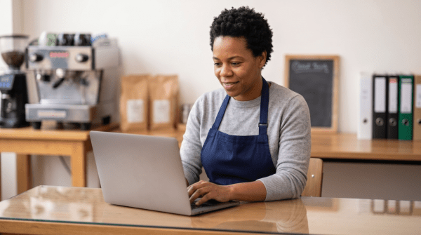 Breakfast cafe owner registering a cafe business as an LLC on a laptop