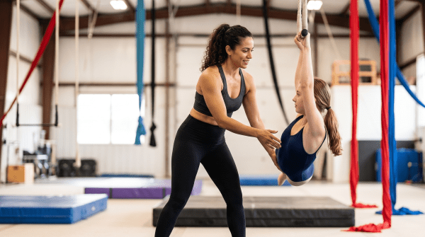 Circus arts school instructor coaching a student on aerial equipment