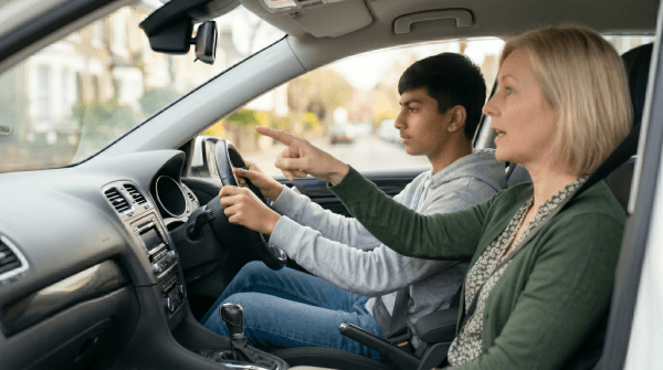 Driving school instructor teaching a student driver the rules of the road during an in-car lesson