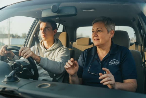 Driving school instructor teaching a student driver the rules of the road during an in-car lesson