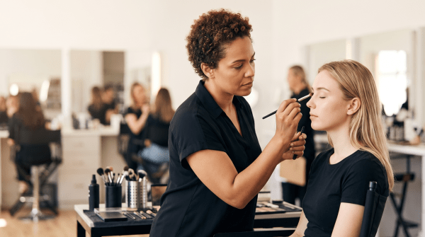 Makeup artist school instructor demonstrating technique to students