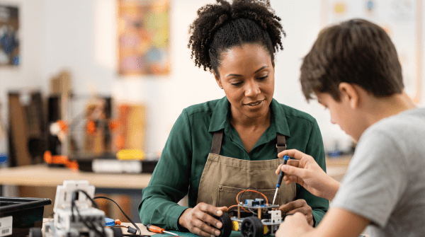 STEM academy instructor guiding students through a hands-on experiment