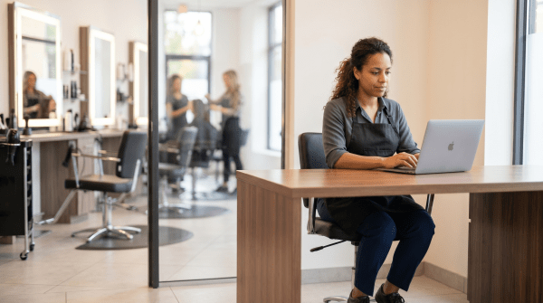Hairdresser registering a salon business as an LLC on a laptop