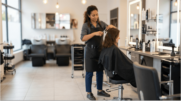 Professional hairdresser cutting and styling a client's hair at a hair salon