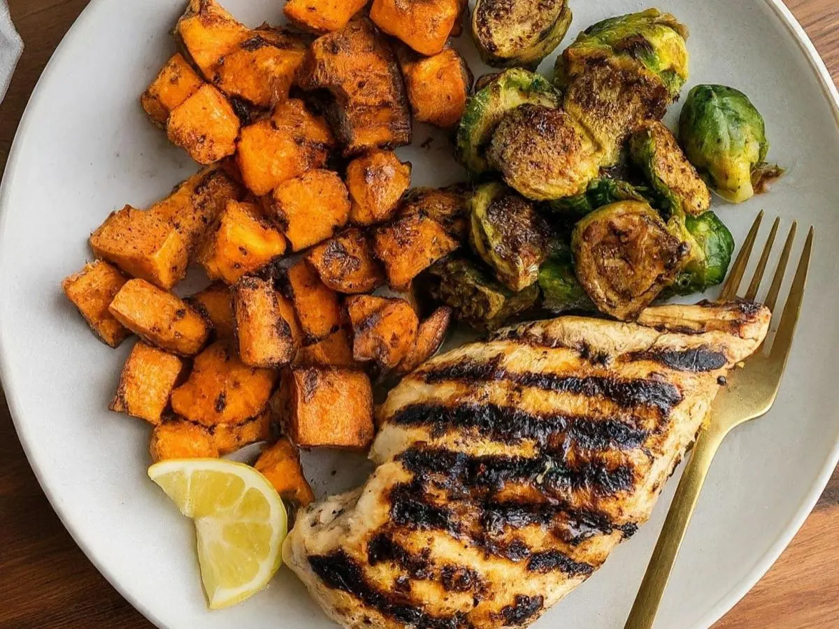 Lemon Herb Grilled Chicken Served with Roasted Sweet Potato & Chili Crisp Brussels Sprouts Lemon Herb Grilled Chicken Served with Roasted Sweet Potato & Chili Crisp Brussels Sprouts