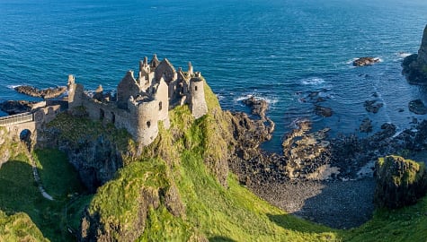 Ruins of medieval Dunluce Castle on a steep cliff on the northern coast of County Antrim, Northern Ireland, UK.
