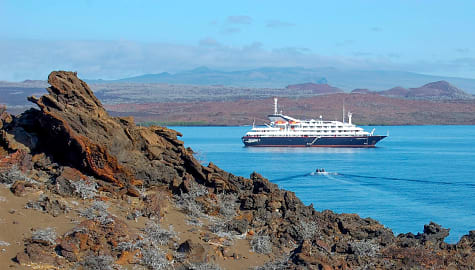 Volcanic landscape with cruise ship anchored in Sullivan bay at Santiago Island, Galapagos, Ecuador