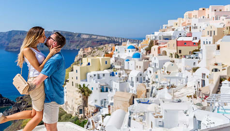 Couple kissing on rooftop overlooking the caldera Santorini, Greece