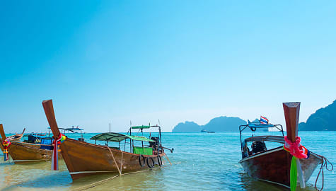 Boats on the beach with beautiful blue sky in Krabi, Thailand.
