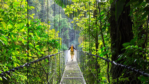 Tourist walking across hanging bridge in La Fortuna, Costa Rica