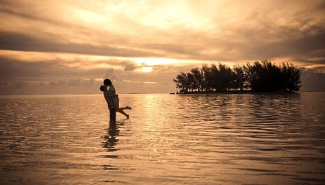 Honeymoon couple on the beach at sunset in Moorea, French Polynesia