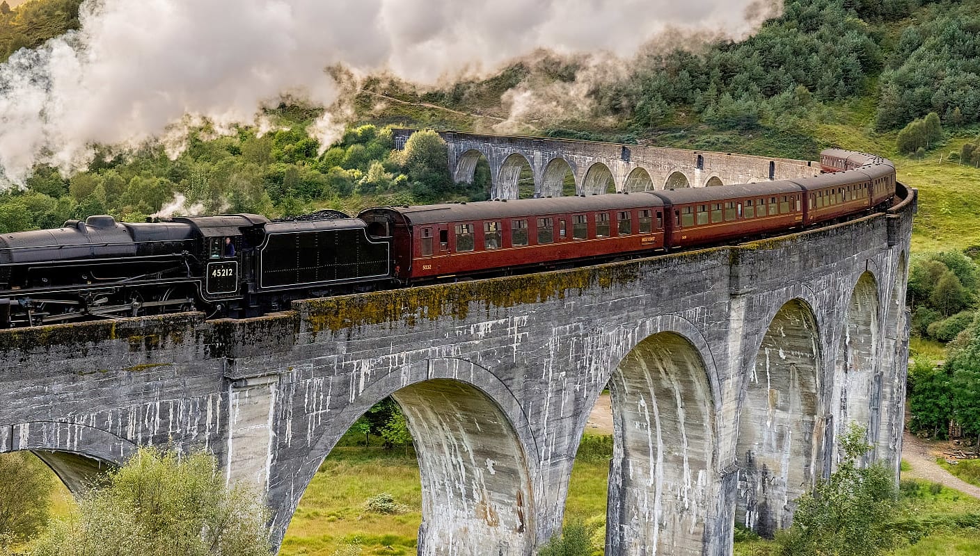 Steam train on the Glenfinnan Viaduct, made famous as the Hogwarts Express, in Scotland