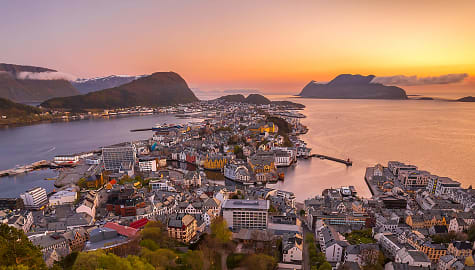 Sun setting on the horizon in Alesund, Norway