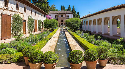 Garden and bell tower at Alhambra Palace in Granada in a beautiful summer day, Spain