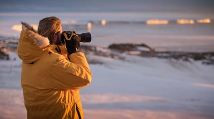A traveler takes photos during an expedition to Antarctica