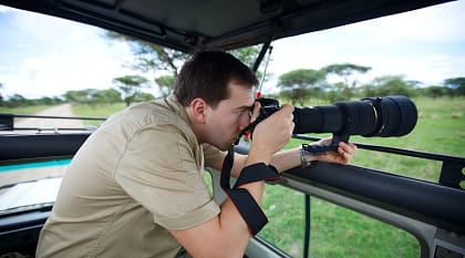 Photographer taking pictures on game drive in Tarangire National Park, Tanzania