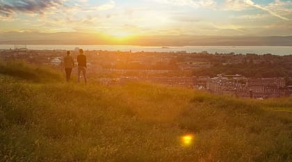 Couple enjoying cityscape at sunset, Edinburgh, Scotland, UK Couple enjoying cityscape at sunset, Edinburgh, Scotland, UK