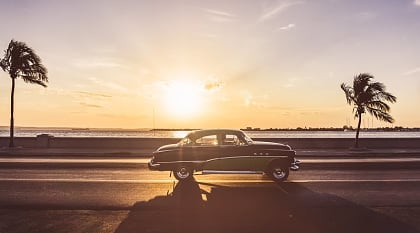 Classic car driving along the Malecon in Havana, Cuba.