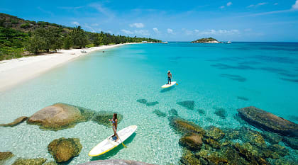 Couple paddle boarding at Lizard Island. Photo Courtesy Lizard Island Couple paddle boarding at Lizard Island