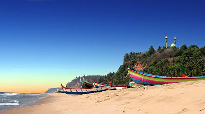 Colorful fishermen boats on beach in front of Varkala south cliff in Kerala, India