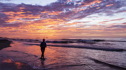 Fisherman silhouetted against the setting sun on Playa Tamarindo in Costa Rica