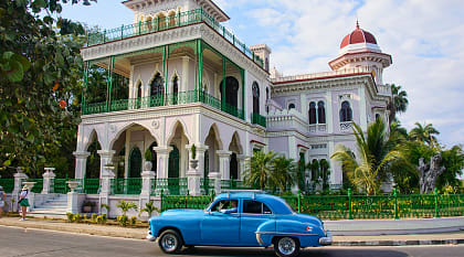 Palacio de Valle in Cienfuegos, Cuba Vintage car passing by Palacio de Valle in Cienfuegos, Cuba