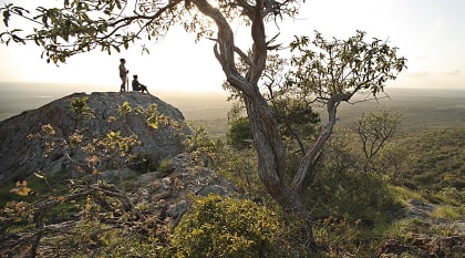 Couple viewing the vast landscape of Phinda Private Game Reserve at sunset in South Africa