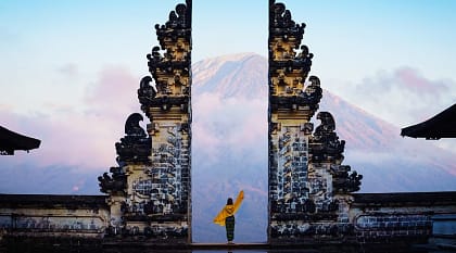 Solo female tourist at temple gates of Pura Penataran Agung Lempuyang, Bali, Indonesia.