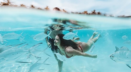 Romance in the Maldives A couple swims in the ocean in the Maldives.