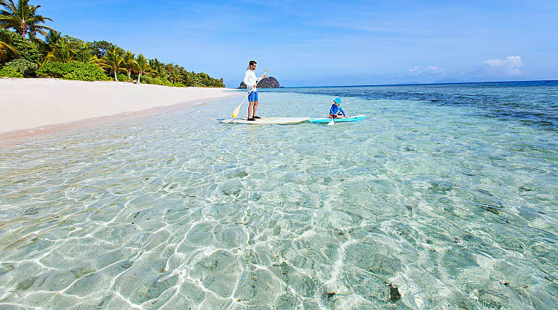 Fiji Vacation for Families Father and son stand up paddle boarding in Fiji