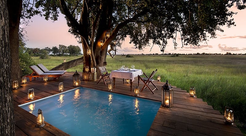 Dining on the pool deck at Duba Plains Camp in the Okavango Delta, Botswana. Photo Courtesy Great Plains Conservation Guest private dining on the pool deck at Duba Plains Camp in the Okavango Delta, Botswana