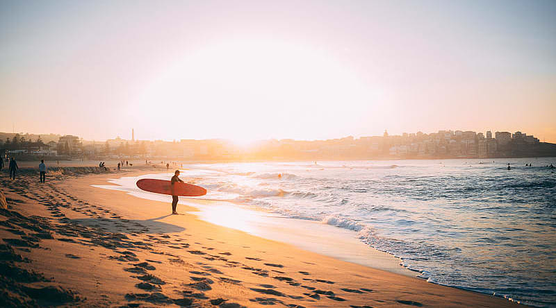 Surfer at sunset on the beach in Bondi, Australia Surfer at sunset on the beach in Bondi, Australia
