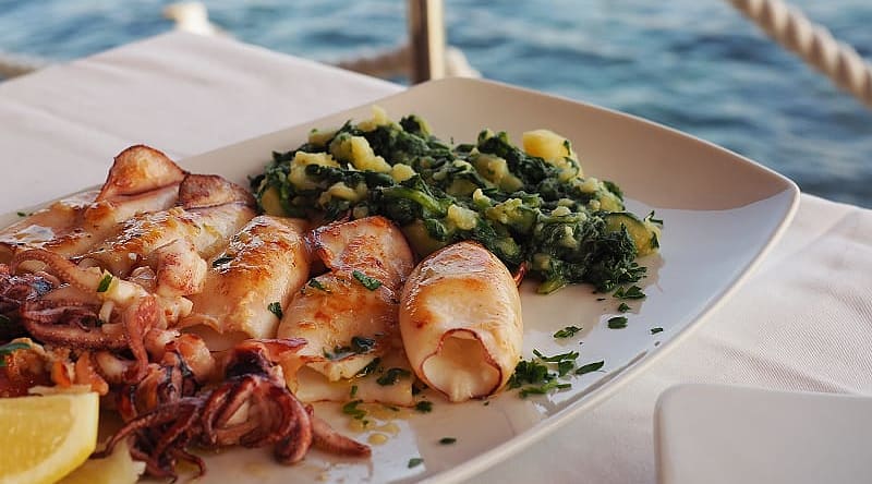 Fried squid with boiled potatoes and Swiss chard. Traditional Croatian cuisine, Rovinj Fried squid with boiled potatoes and Swiss chard. Traditional Croatian cuisine, Rovinj