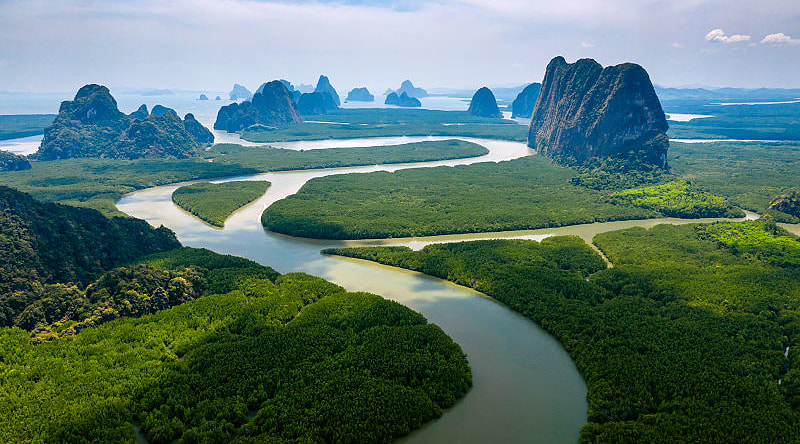 Aerial view of towering limestone cliffs and mangrove forest in Phang Nga Bay, Thailand. Aerial view of towering limestone cliffs and mangrove forest in Phang Nga Bay, Thailand.