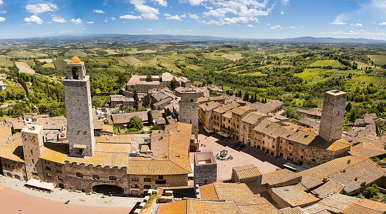 San Gimignano in Tuscany, Italy San Gimignano surrounded by the green rolling hills and vineyards of Tuscany, Italy