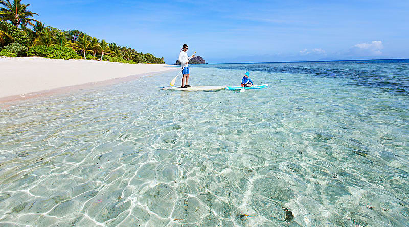 Fiji Vacation for Families Father and son stand up paddle boarding in Fiji