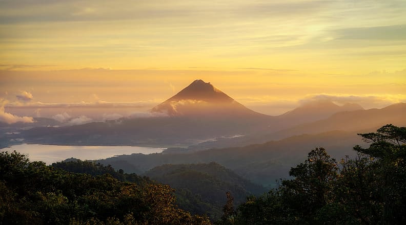 Arenal Volcano in Costa Rica Sunrise view of Arenal Volcano with clouds over Lake Arenal in Costa Rica