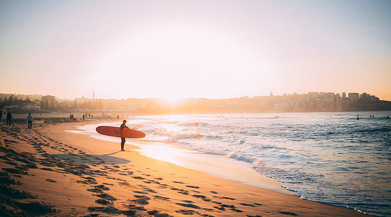 Surfer at sunset on the beach in Bondi, Australia Surfer at sunset on the beach in Bondi, Australia