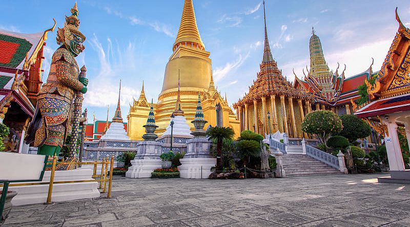 Wat Phra Kaew in Bangkok, Thailand Grand Palace in Bangkok with golden stupa and ornate temples in Wat Phra Kaew at sunset.