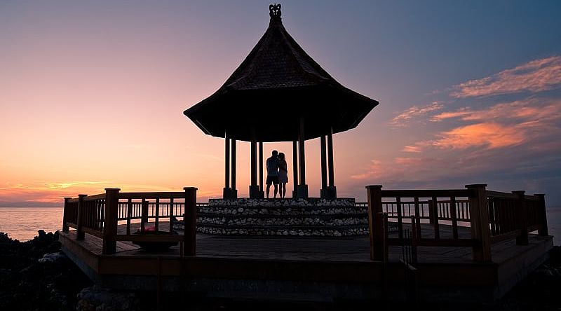 Silhouette of couple enjoying romantic sunset in Bali