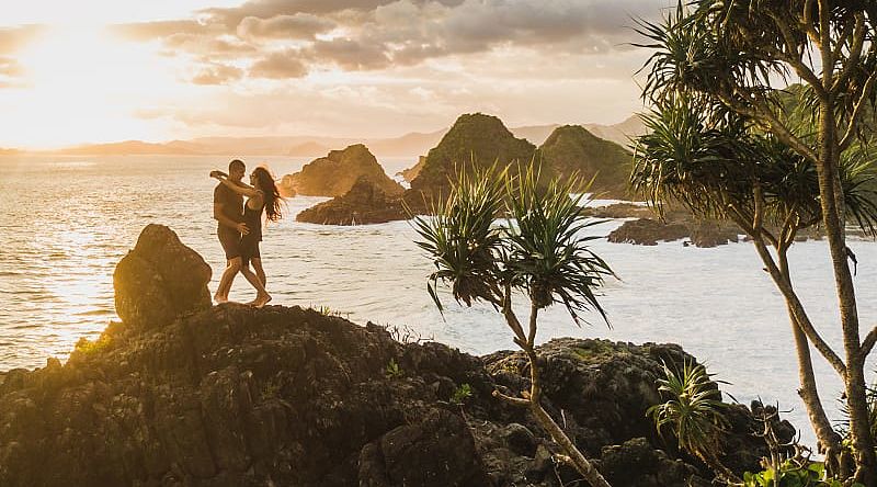 Honeymoon couple at sunset on the rock in Bali, Indonesia