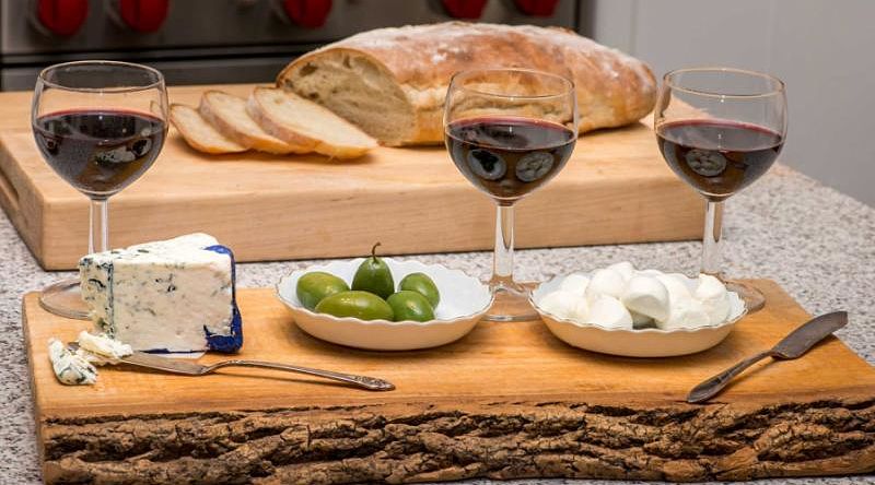 Sicilian setting - wine glasses, olives, blue cheese, bocconcini and ciabatta.