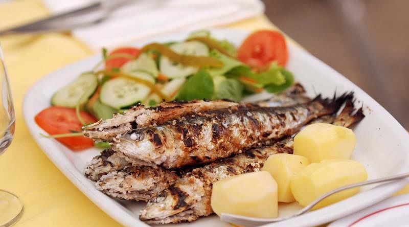 Famous grilled Portuguese sardines with potatoes and salad