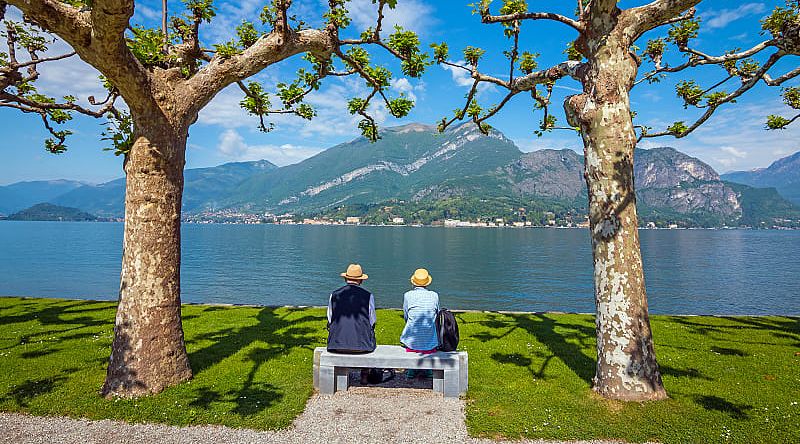 Senior couple enjoying the blue surface of Lake Como, Italy Senior couple enjoying the blue surface of Lake Como, Italy