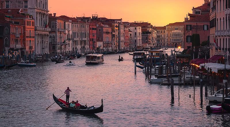 Couple taking sunset gondola ride on the Grand Canal in Venice, Italy