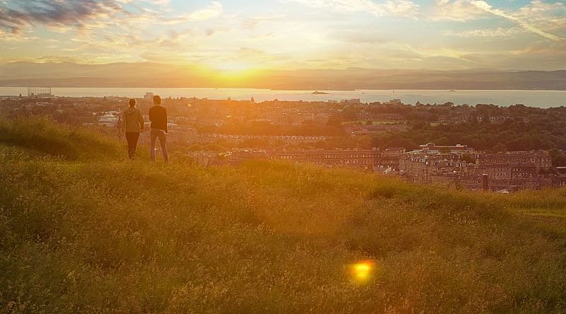 Couple enjoying cityscape at sunset, Edinburgh, Scotland, UK